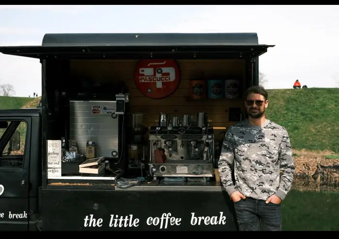 Åben kaffevogn med espressomaskine og barista klar til at servere